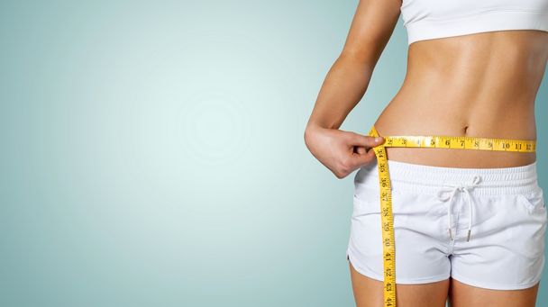 young woman measuring her thin waist  - Foto, Imagem