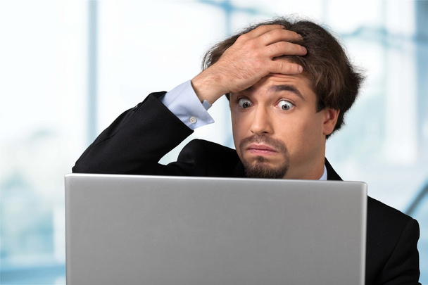 Portrait of upset businessman with laptop - Foto, afbeelding