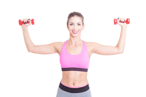Pretty girl at gym holding pair of dumbbells - Фото, изображение
