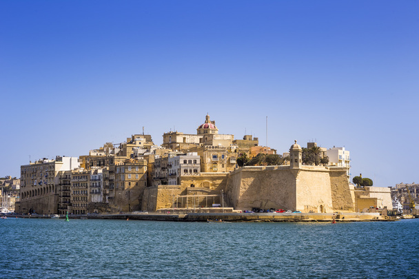 Malta - Las antiguas murallas de Senglea y Gardjola Jardines disparados desde La Valeta en un día soleado con cielo azul claro
 - Foto, Imagen