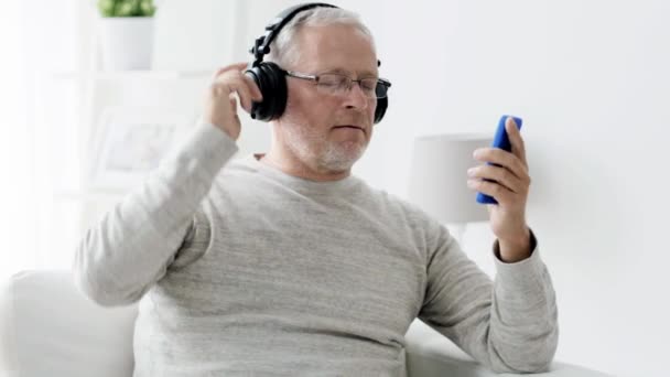 happy senior man with smartphone and headphones 92 - Filmati, video