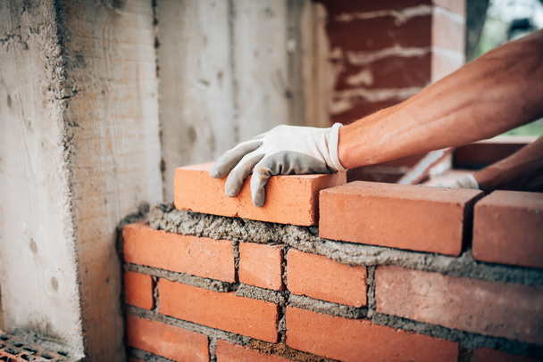 Construction worker laying bricks on exterior walls - Φωτογραφία, εικόνα