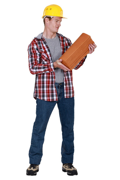 Tradesman holding shingles - Foto, Imagen