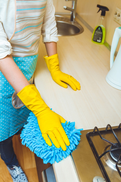 La mujer en el delantal hace la limpieza
 - Foto, imagen