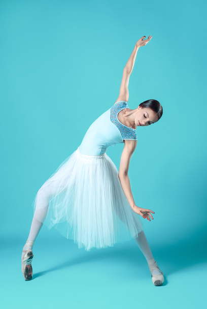 Ballerina in white dress posing on toes, studio background. - Fotoğraf, Görsel