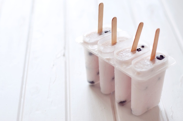 Ice popsicles with yougurt and blueberries in ice lolly mold - Фото, зображення
