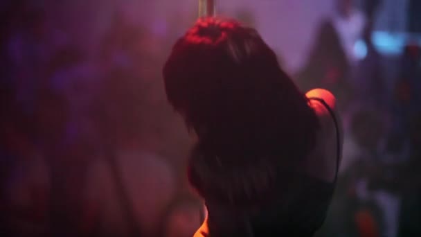 Mädchen tanzt Striptease auf Pylon im Nachtclub - Filmmaterial, Video