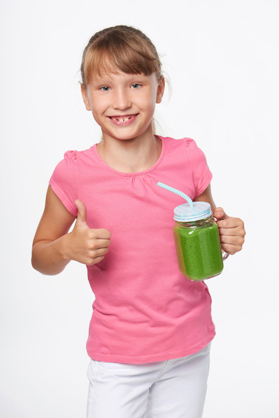 Girl holding jar tumbler mug with green smoothie drink - Foto, Imagem