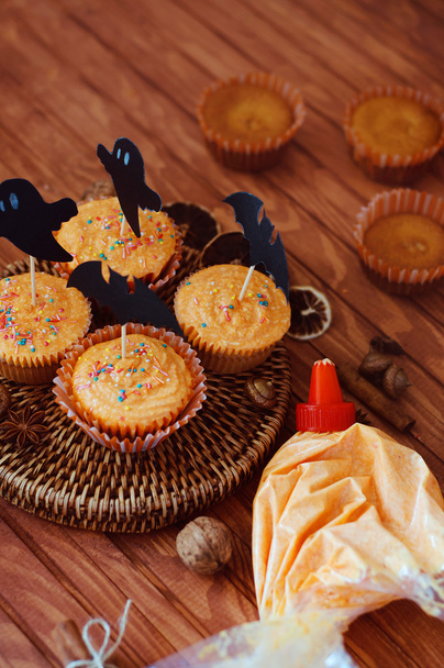 Pastelitos espolvoreados de naranja de Halloween con crema de calabaza y fantasma
 - Foto, Imagen