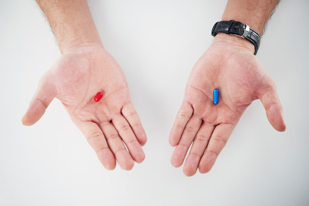 Долоні з червоними і синіми таблетками
 - Фото, зображення