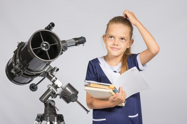 Studentessa si chiedeva e ammirato leggendo un libro di testo mentre in piedi al telescopio
 - Foto, immagini