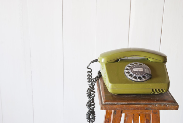 Teléfono retro giratorio sobre mesa vintage de madera. Fondo blanco
  - Foto, imagen
