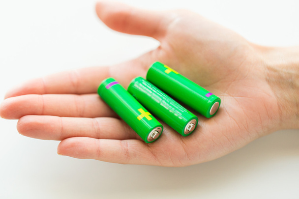 close up of hand holding green alkaline batteries - Foto, Imagem