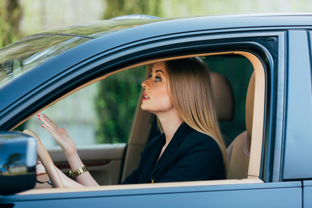 Meisje rijdt een auto met verschillende gebaar en emoties - Foto, afbeelding