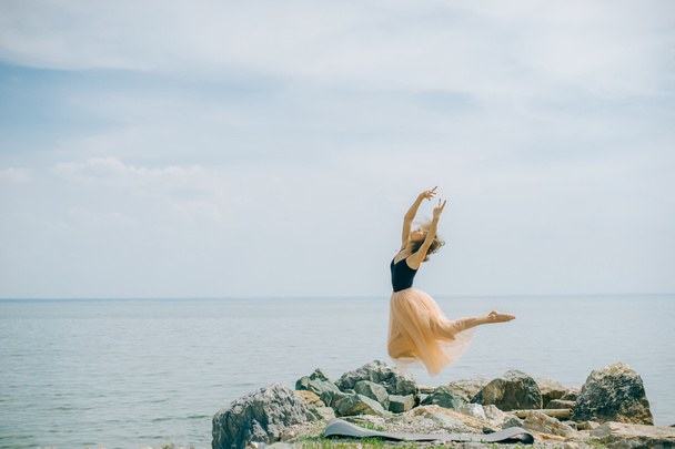 girl jumping against the sky. ballet items - Фото, изображение