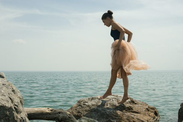 girl dancing on the rocks on the shore - Foto, Bild