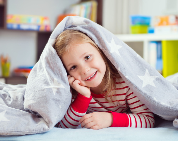 Vrij klein meisje liggen onder deken - Foto, afbeelding
