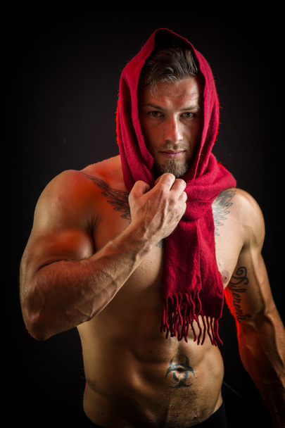 Muscular shirtless man with scarf around face - 写真・画像