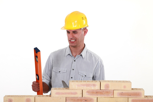 Bricklayer with a spirit level - Foto, afbeelding
