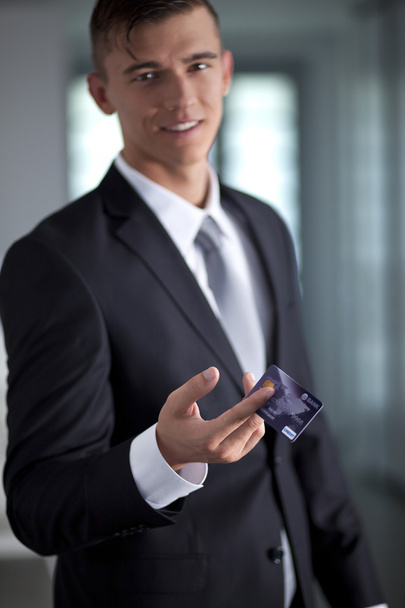 Giovane uomo d'affari sorridente di successo in possesso di una carta di credito
 - Foto, immagini