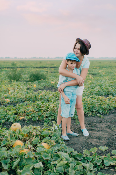 Mom and son on a field with melons - 写真・画像