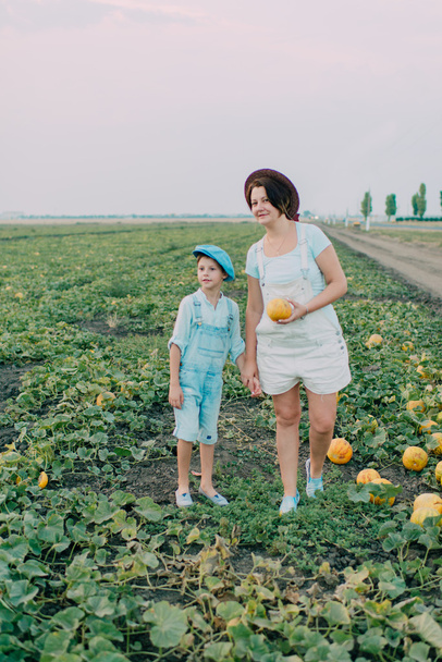 Mom and son on a field with melons - Fotografie, Obrázek