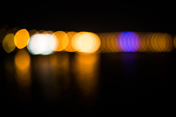 Beautiful blurred city lights with bokeh effect reflected on water background - Photo, Image