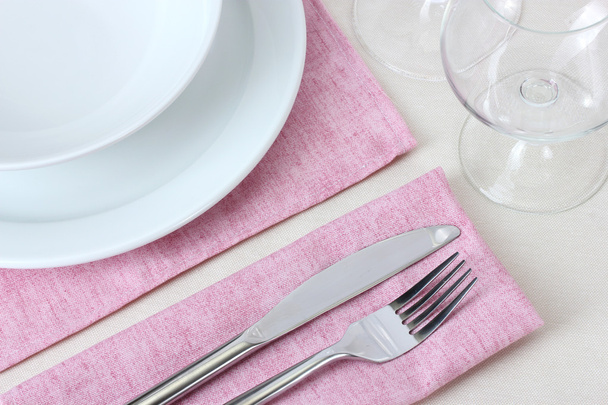 Table setting with fork, knife, plates and napkin - Fotó, kép
