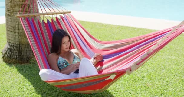 Kobieta w bikini czytania książki w hamaku - Materiał filmowy, wideo
