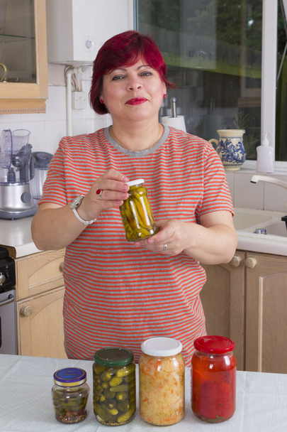 Зріла жінка з маринованими овочами
 - Фото, зображення