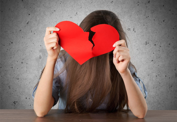girl holding broken heart symbol - Foto, afbeelding