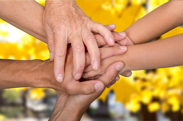 Familia sosteniendo sus manos juntas
 - Foto, Imagen