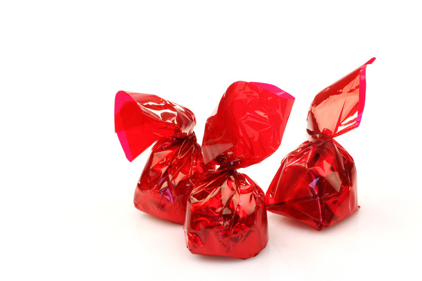 Бонбоны, завернутые в красную блестящую бумагу
 - Фото, изображение