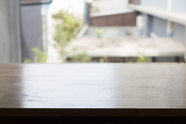 houten tafel naast venster voor uw product weergeven - Foto, afbeelding