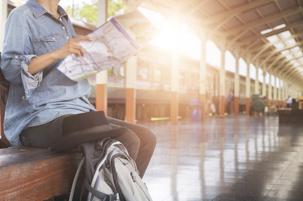 woman holding map with backpack at train station - Photo, image