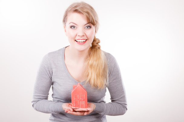 Smiling woman holding house model. - Foto, afbeelding