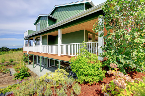 Вид на задний двор трехэтажного зеленого дома
 - Фото, изображение
