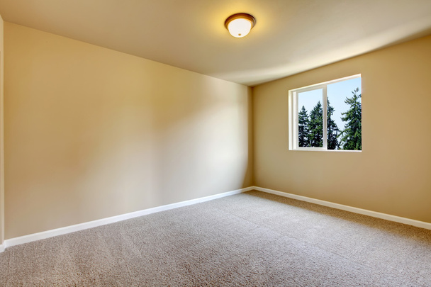 Яркая пустая комната с одним окном и бежевыми стенами
 - Фото, изображение