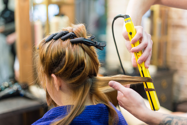 επαγγελματία κομμωτή χρησιμοποιώντας σίδερο για μπούκλες μαλλιά μπούκλες - Φωτογραφία, εικόνα