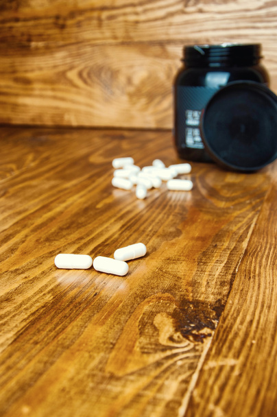Kreatyna tabletki na drewnianym stole - Zdjęcie, obraz
