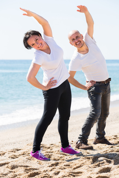 Para uprawiająca jogę na plaży - Zdjęcie, obraz