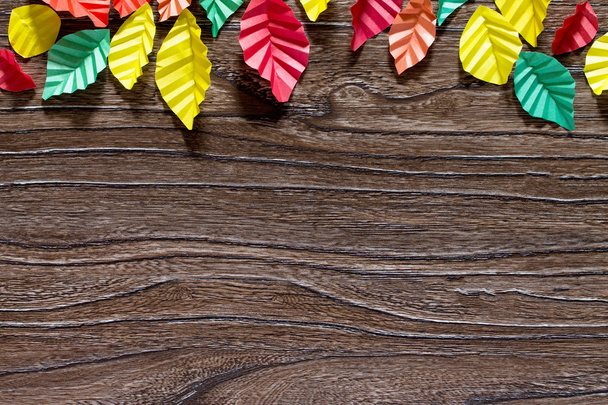 Осіннє листя на фоні барвистого паперового листа орігамі на вугрі
 - Фото, зображення