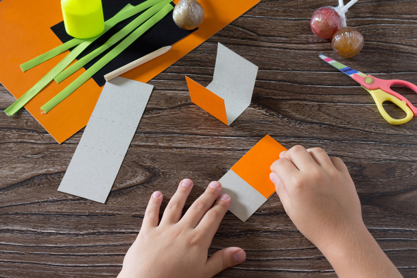 The child create a greeting packaging for lollipop on Halloween  - Photo, Image