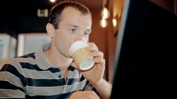 Mid shot Man working on computer and drink coffee in cafe - Materiał filmowy, wideo