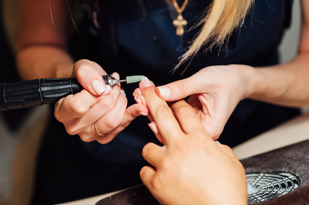 Woman in salon receiving manicure - 写真・画像