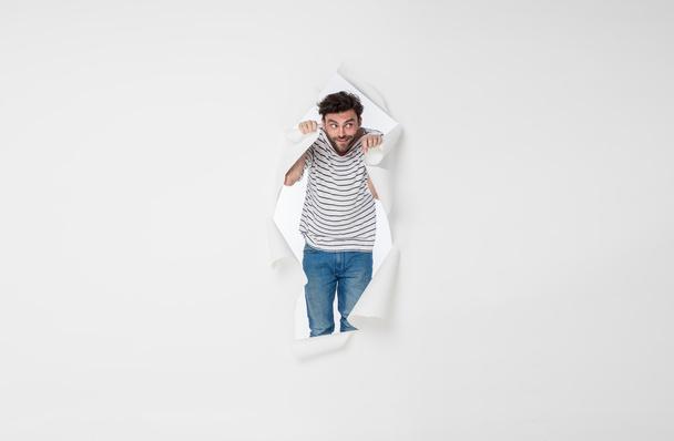 casual man breaking the paper background  - Foto, afbeelding