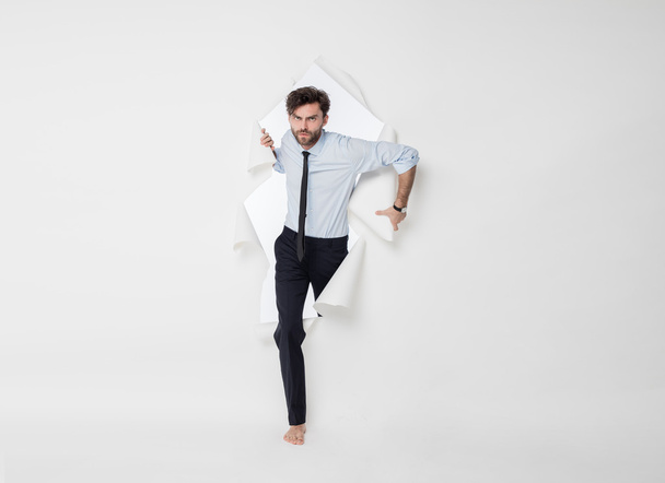 office man with elegant outfit and tie breaking the paper backgr - Фото, изображение