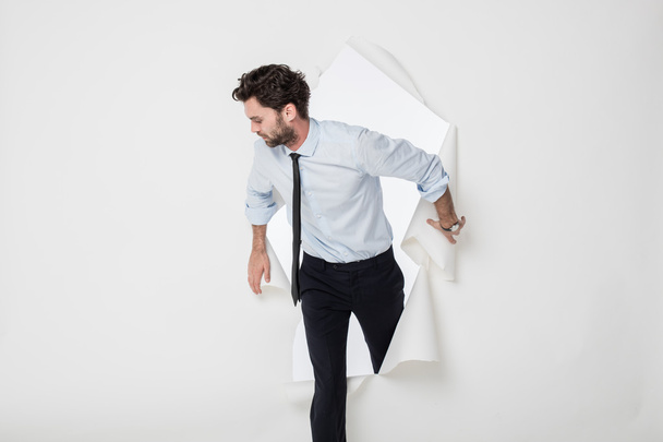 office man with elegant outfit and tie breaking the paper backgr - Foto, Bild