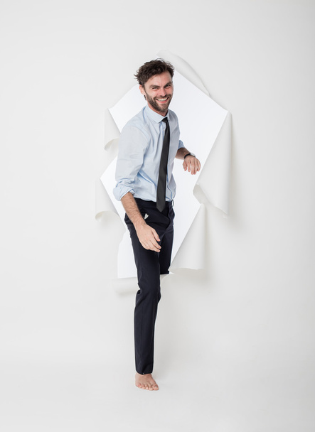 office man with elegant outfit and tie breaking the paper backgr - Zdjęcie, obraz