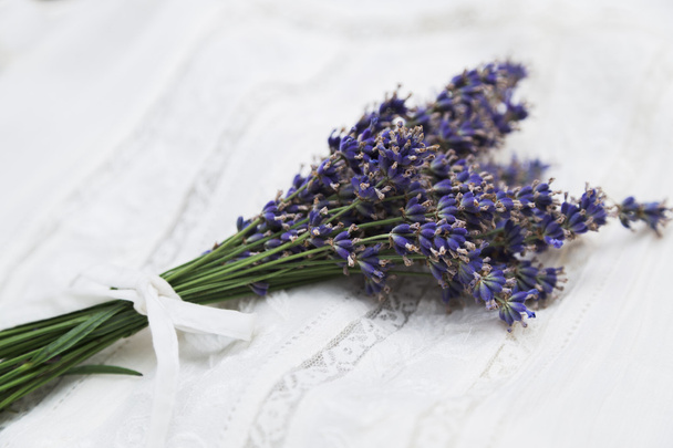 Bouquet of purple lavender tied with ribbon on lace cloth - Фото, зображення